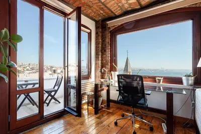 an office with a desk and a chair in a room with windows at Alaattin Apartments in Istanbul