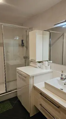 a white bathroom with a sink and a shower at Taksim'de 2 yatak odalı daire, güvenlik, havuz, spa, otopark in Istanbul