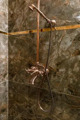 a shower head in a bathroom with a stone wall at The Ottoman apartment in Istanbul