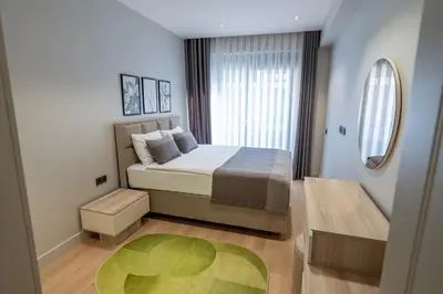 a small bedroom with a bed and a green rug at Boamonti Residence Sisli Apart in Istanbul