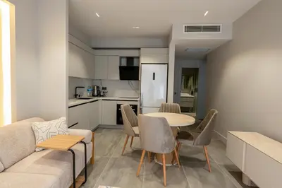 a living room with a table and chairs and a kitchen at Boamonti Residence Sisli Apart in Istanbul