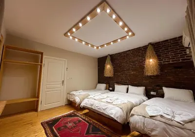 a bedroom with three beds and a brick wall at Wooden Villa in Istanbul