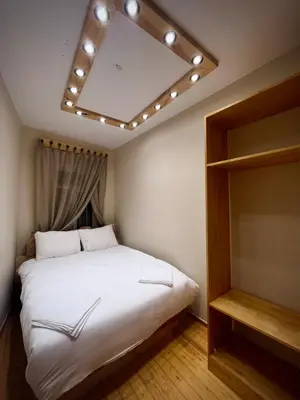 a bedroom with a large white bed with lights on the ceiling at Wooden Villa in Istanbul