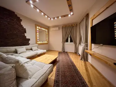 a living room with a couch and a flat screen tv at Wooden Villa in Istanbul
