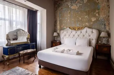 a bedroom with a large white bed and a painting at Grand Historic 3BD2Bath Galata Tower Pad! #408 in Istanbul