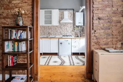 a kitchen with white cabinets and a brick wall at Grand Historic 3BD2Bath Galata Tower Pad! #408 in Istanbul
