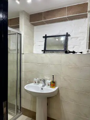 a bathroom with a sink and a glass shower at Balat Homes & Apartments Nick in Istanbul