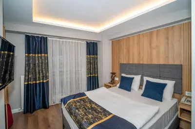 a bedroom with a large bed with blue pillows at Hotel Martini in Istanbul