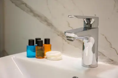 a bathroom sink with a faucet and two bottles of soap at Firuzağa Retreat Studio in Beyoğlu in Istanbul