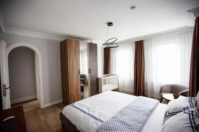 a bedroom with a bed and a chair and windows at Boğaz Yalı Dairesi in Istanbul