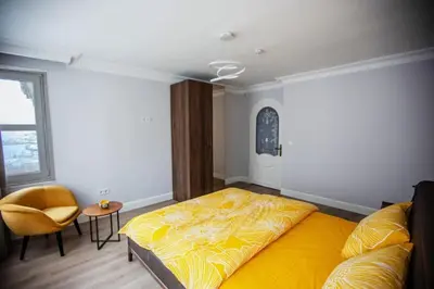 a bedroom with a large yellow bed and a chair at Boğaz Yalı Dairesi in Istanbul