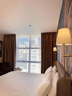 a bedroom with a large bed and a large window at Park Dedeman Sisli - Istanbul City Center in Istanbul