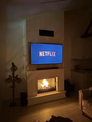 a living room with a television above a fireplace at Doğayla İç içe Lüks Villa in İznik