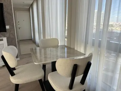 a dining room with a glass table and chairs at 91 sqm luxury apartment with double view in Istanbul