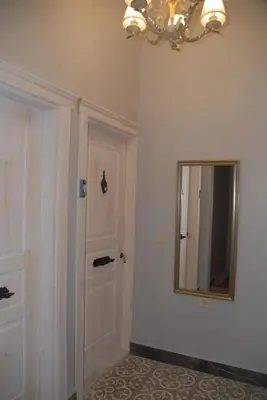 a hallway with a door and a mirror and a chandelier at Ozcans Pera Flats 4 in Istanbul