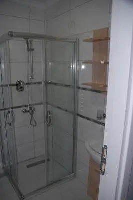 a shower with a glass door in a bathroom at Ozcans Pera Flats 5 in Istanbul