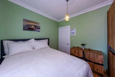 a bedroom with a white bed and green walls at Şehir Manzaralı Ferah Daire in Istanbul
