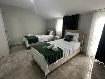 a bedroom with two beds with green and white sheets at Royal Suit in Bandırma