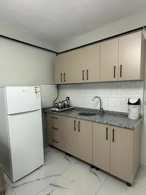 a kitchen with white cabinets and a white refrigerator at Royal Suit in Bandırma