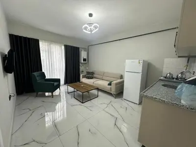 a kitchen and living room with a couch and a refrigerator at Royal Suit in Bandırma