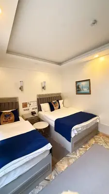 a hotel room with two beds with blue sheets at Kurban Otel in Istanbul