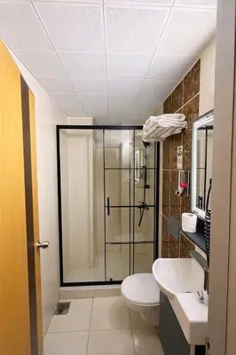 a bathroom with a shower and a toilet and a sink at Kurban Otel in Istanbul