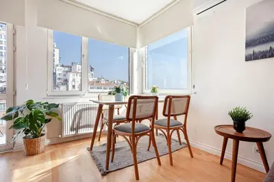 a dining room with a table and chairs and windows at Magnificent View Great Location in Istanbul