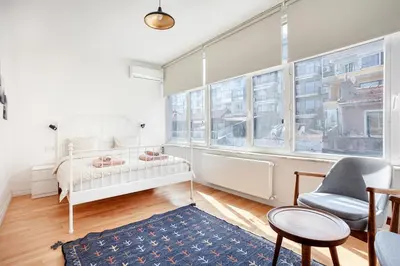 a bedroom with a bed and a chair and windows at Magnificent View Great Location in Istanbul