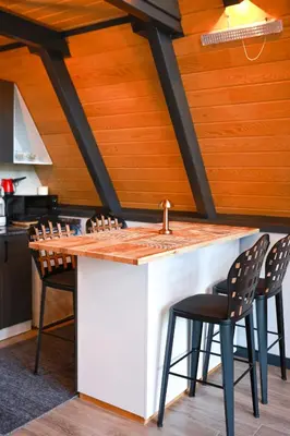 a kitchen with a counter with a sink and chairs at Zeyno Sapanca in Sapanca