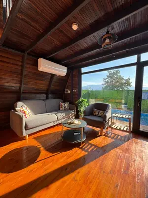 a living room with a couch and a table at Shadeoffgreenbungalow