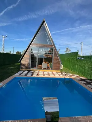 a small house with a pool in front of it at Shadeoffgreenbungalow