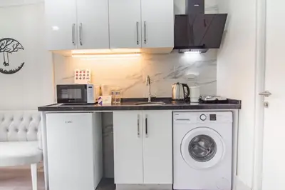 a kitchen with a sink and a washing machine at Cozy 1BR with Inviting Balcony in Beylikduzu