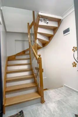 a wooden staircase in a room with white walls at Cozy 1BR with Inviting Balcony in Beylikduzu