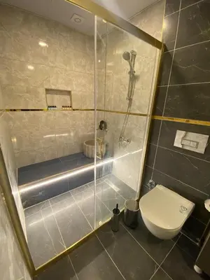 a bathroom with a toilet and a glass shower at Royal Fsm Suites in Istanbul