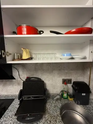 a kitchen counter with a sink and some dishes on shelves at Royal Fsm Suites in Istanbul