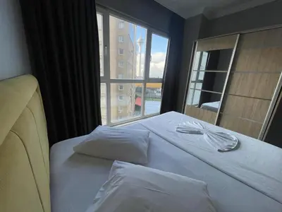 a bed in a room with a large window at Ser Suite Apart Hotel in Esenyurt