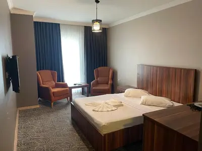 a hotel room with a bed and two chairs at Ser Suite Apart Hotel in Esenyurt