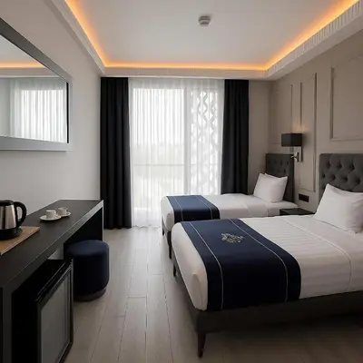 a hotel room with two beds and a desk at Loft Airport Hotel in Arnavutköy