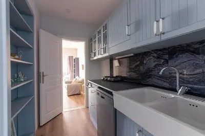 a kitchen with white cabinets and a sink at Modern and Cozy 2BR in Vibrant Cihangir in Istanbul