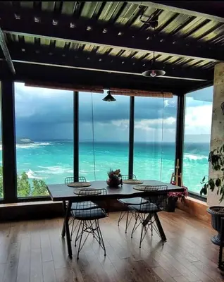a dining room with a table and chairs and the ocean at Marina Boutique Hotel Istanbul Airport in Karaburun