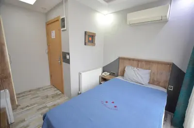 a bedroom with a blue bed in a room at Tüm Palace Otel in Bandırma