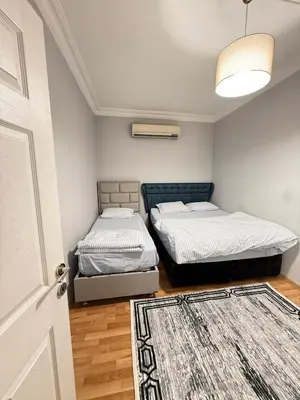 two beds in a room with a door and a rug at Residence 4 in Istanbul