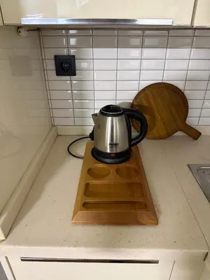 a tea kettle on a wooden tray on a kitchen counter at Trio Houses in Istanbul