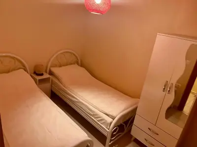 a small room with two beds and a cabinet at Next to Cevahir Shopping Mall Perfect location comfortable luxury apartment in Istanbul