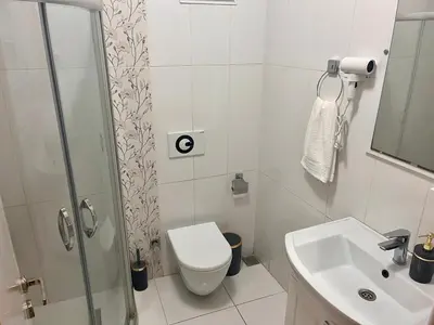 a white bathroom with a toilet and a sink at Next to Cevahir Shopping Mall Perfect location comfortable luxury apartment in Istanbul