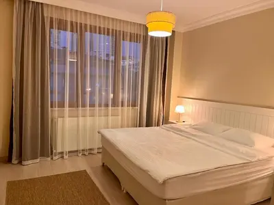 a bedroom with a bed and a large window at Next to Cevahir Shopping Mall Perfect location comfortable luxury apartment in Istanbul