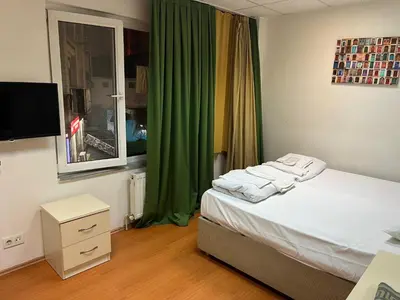a bedroom with a bed and a window with green curtains at Bahar 5 in Istanbul