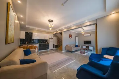 a living room with blue couches and a kitchen at Country Life Sapanca in Sapanca