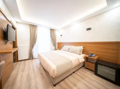 a hotel room with a bed and a flat screen tv at Zirvesta Otel in Istanbul