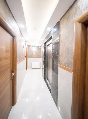 a corridor of a bathroom with a toilet and a door at Zirvesta Otel in Istanbul